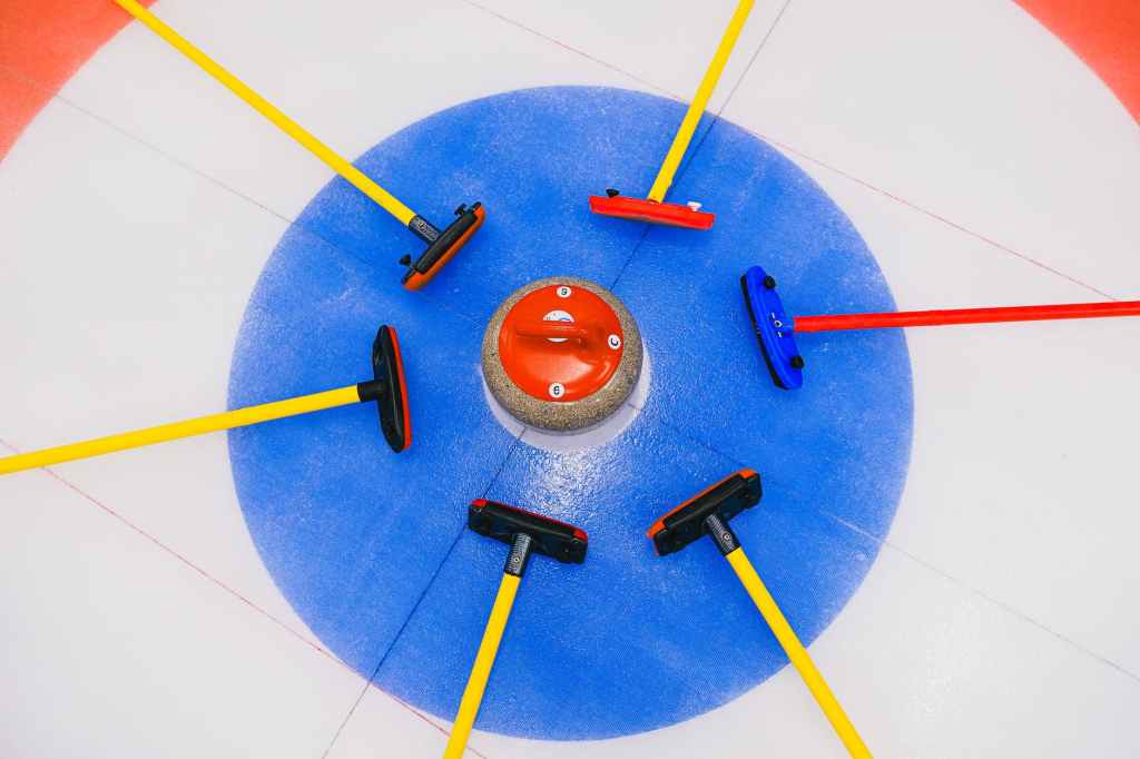 betting on curling stone and brushes in house