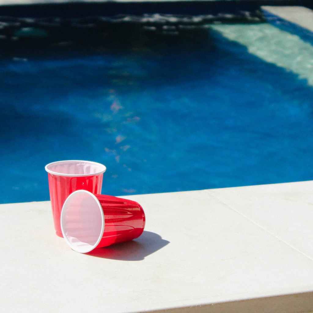 two red and white disposable cups on gray ceramic tiles photo